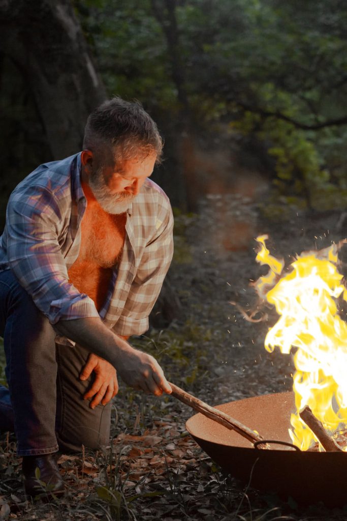 Rugged man by a campfire.